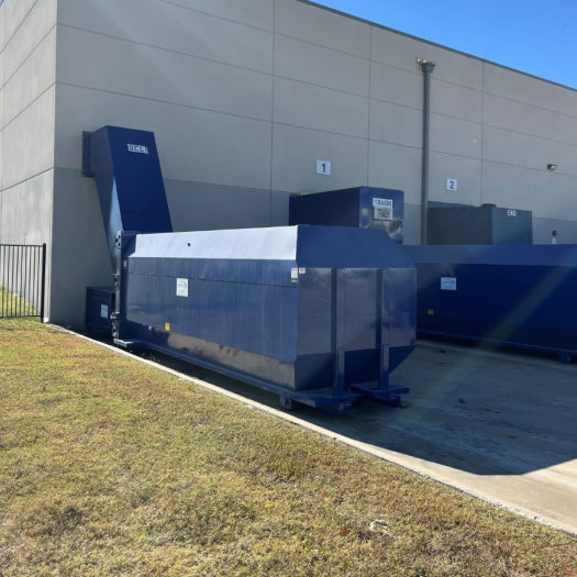 Equipment detail _ stationary compactors 3 CRA blue stationary compactor outside building